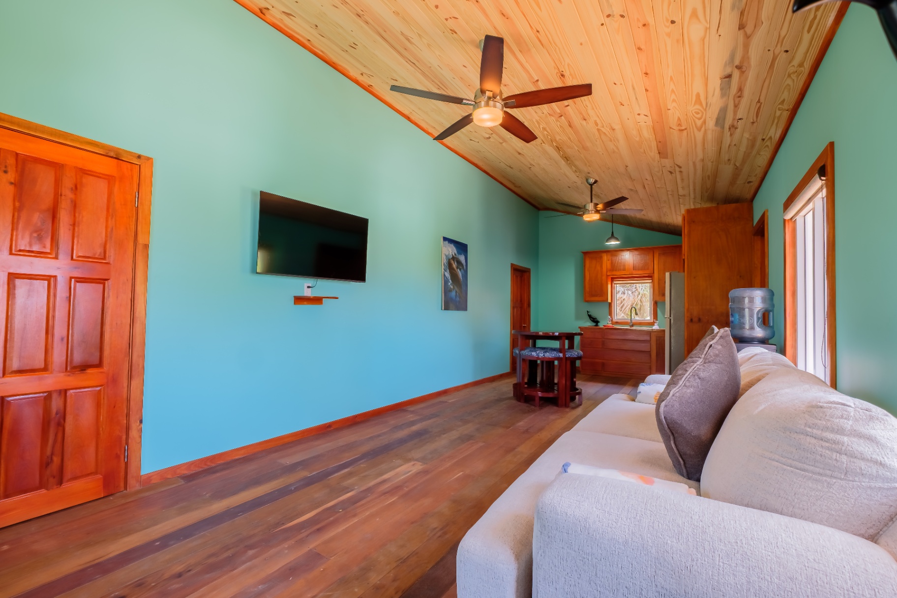 Studio living room with vaulted pine ceiling and dolphin artwork