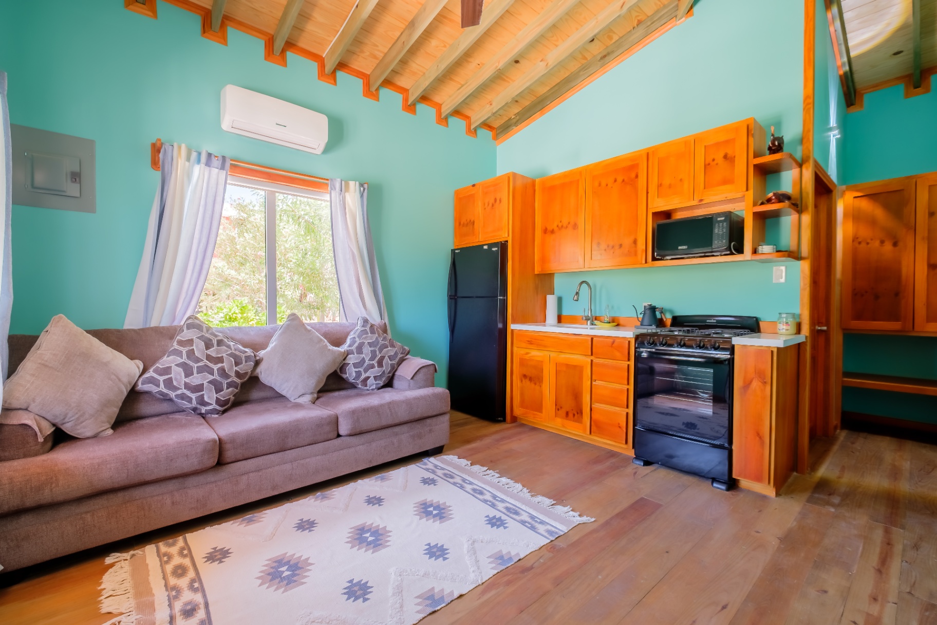 Turquoise living room and pine kitchen with vaulted beam ceiling