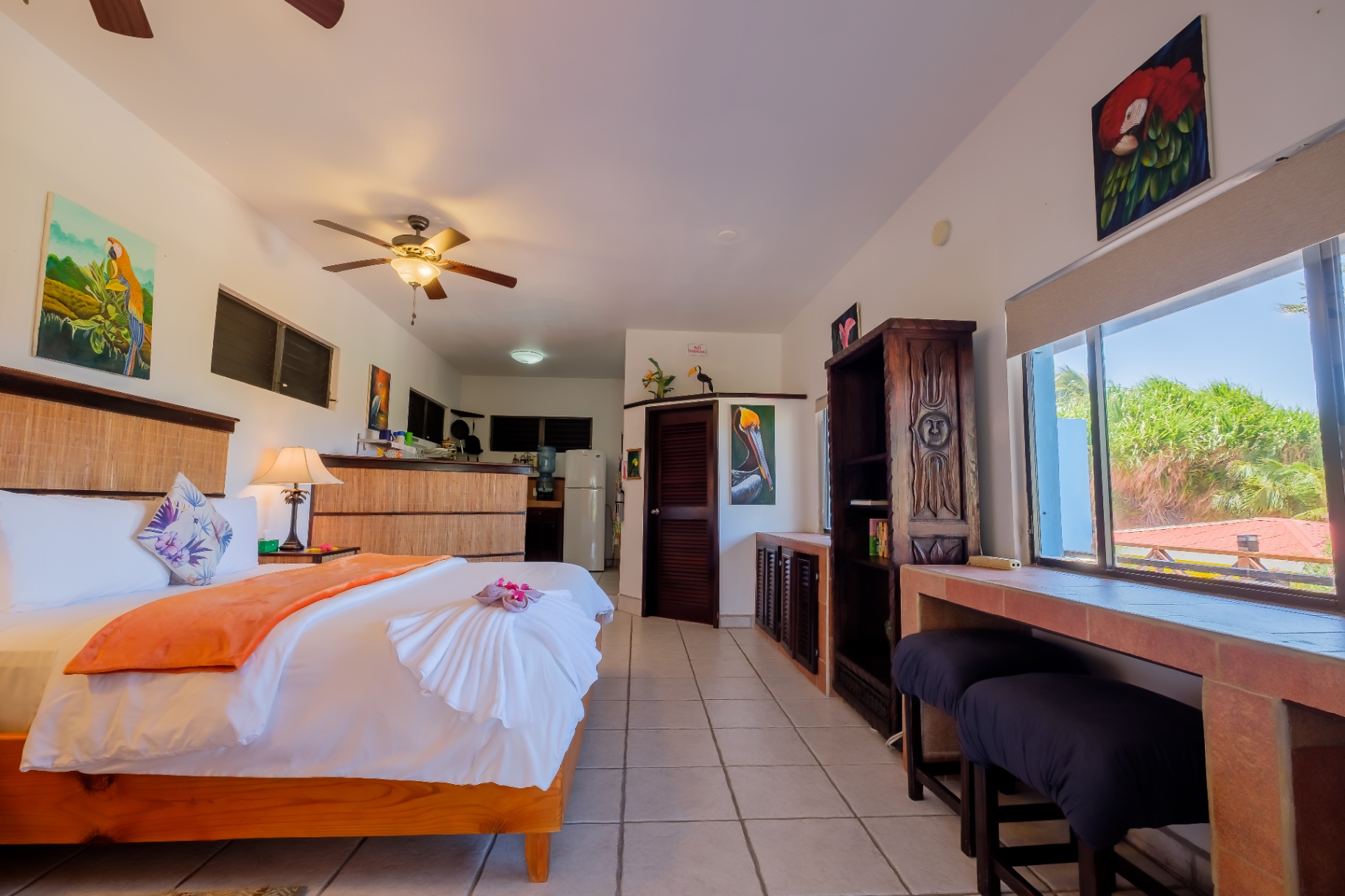 Studio open to kitchenette with tropical artwork