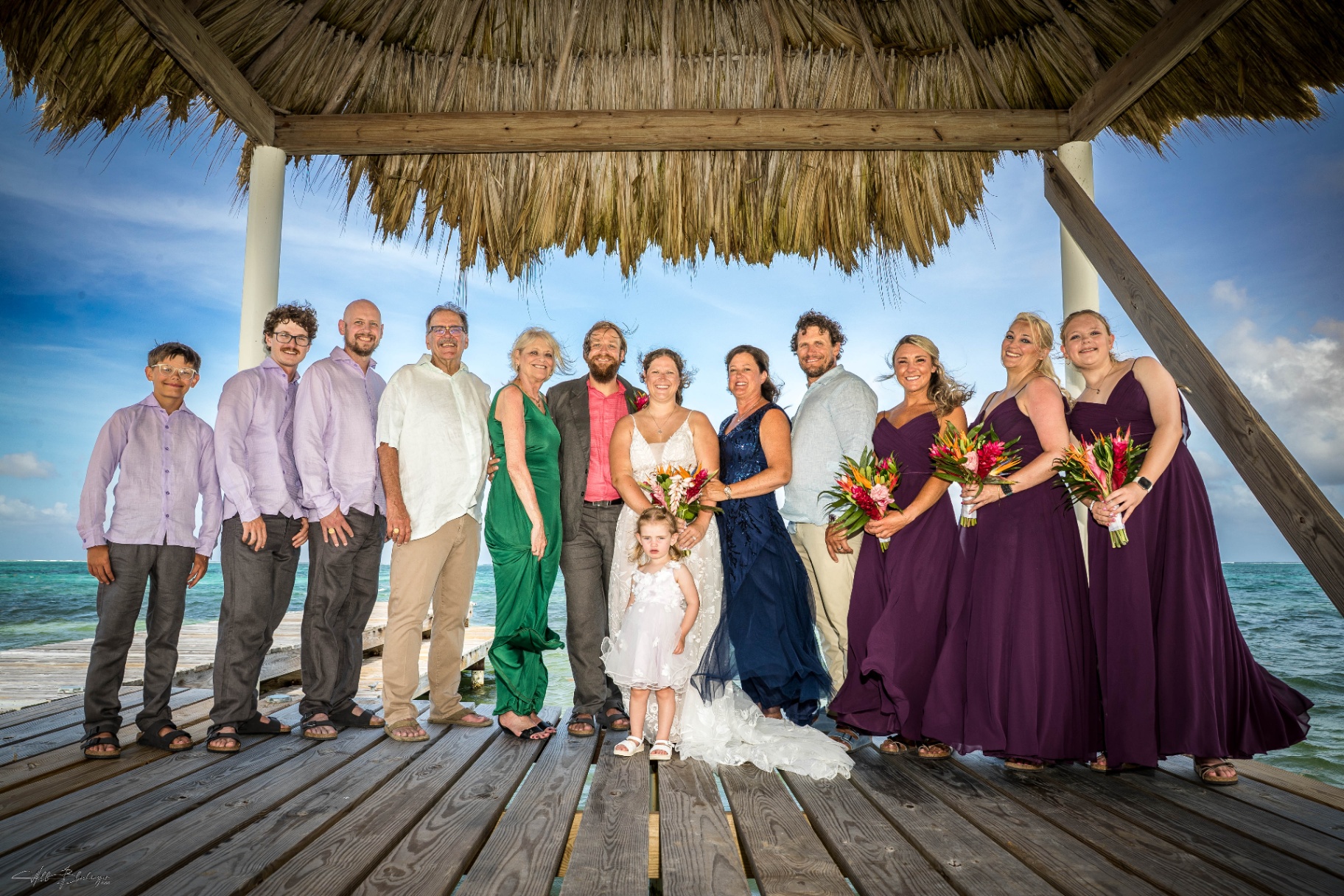 Wedding party and family portrait on the dock under the thatched palapa