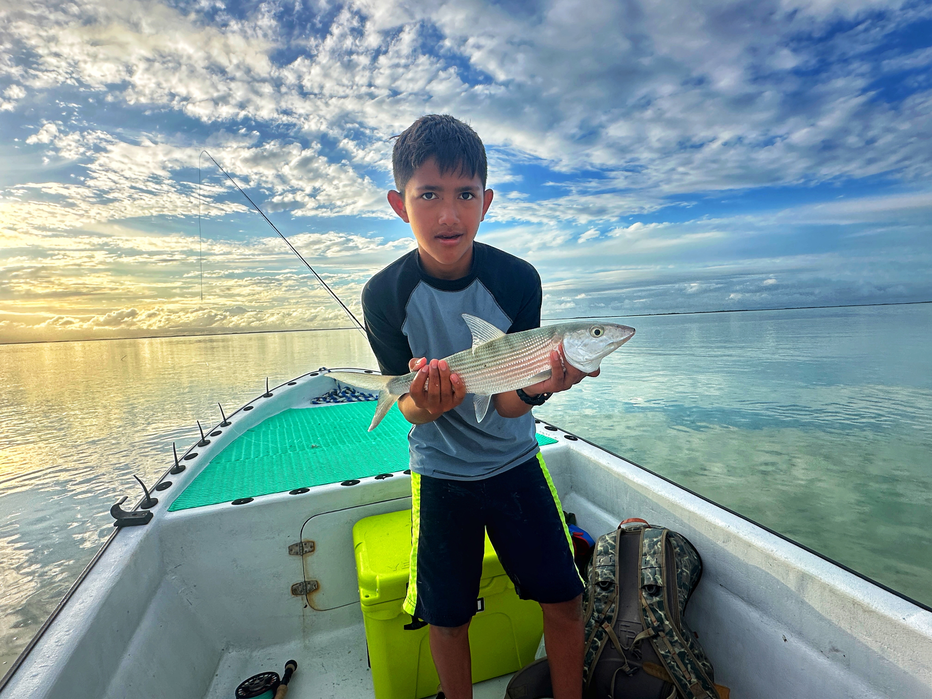 Young angler with a bonefish at sunrise on the Belize flats