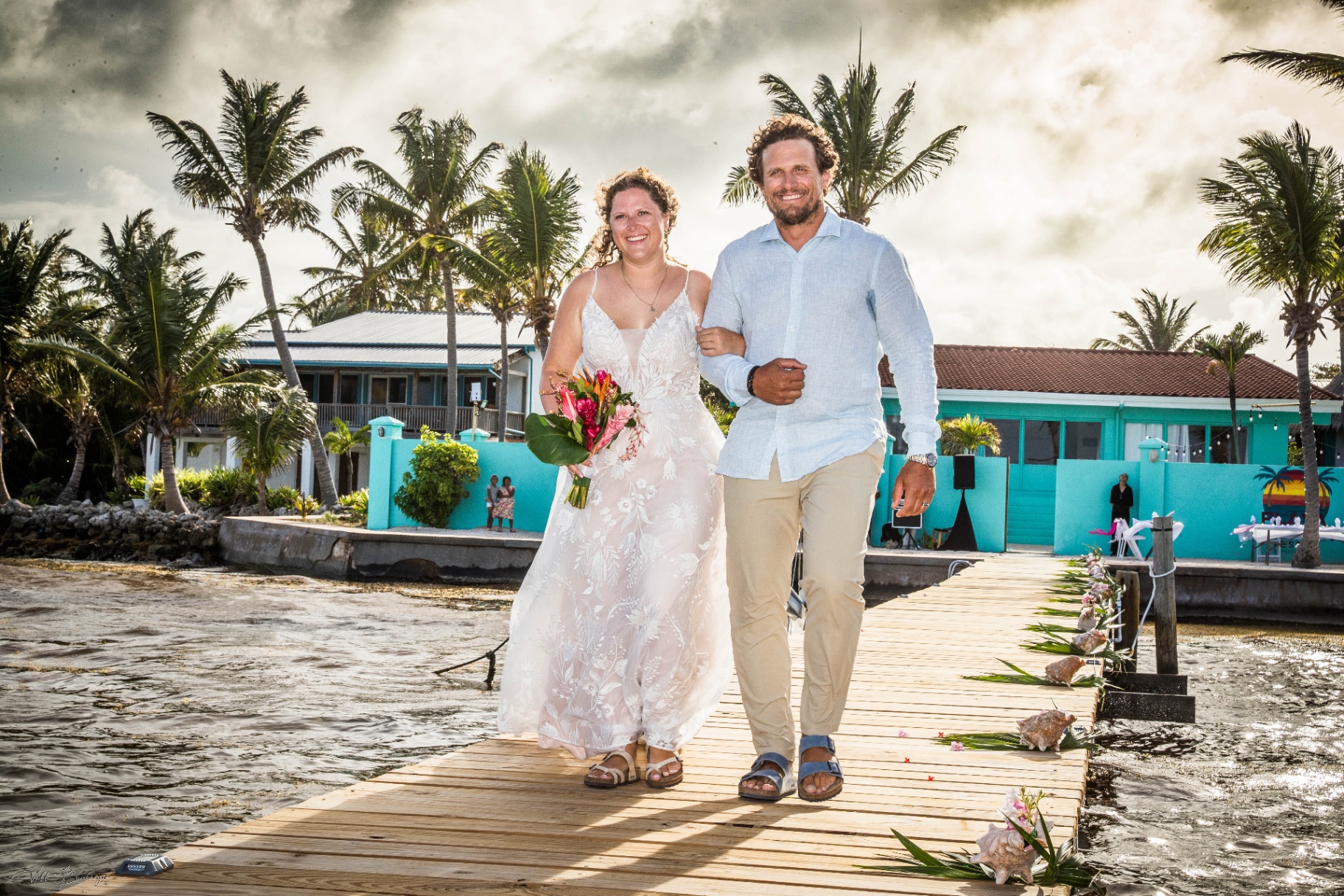 Bride and groom walking down the dock after their ceremony at Playa Blanca