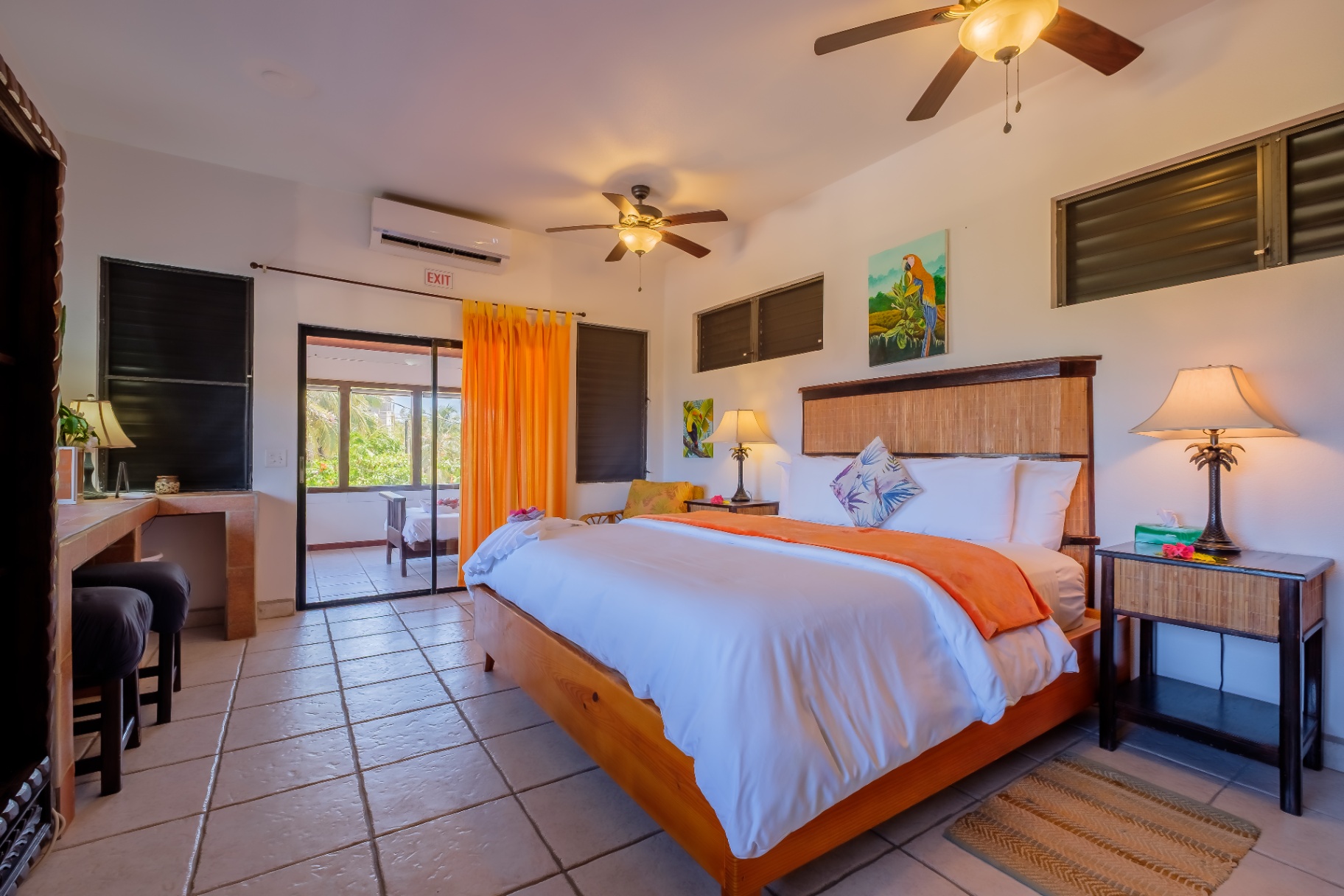 King bedroom suite with parrot artwork and sliding doors to balcony