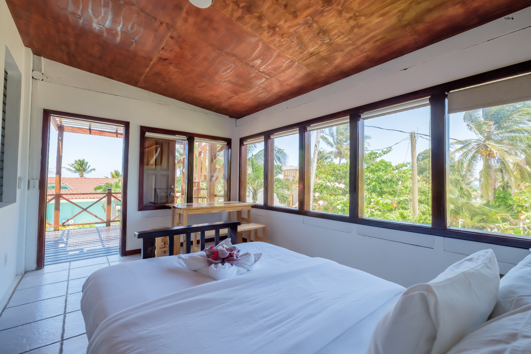 Upstairs sunroom bedroom with copper ceiling and wraparound windows