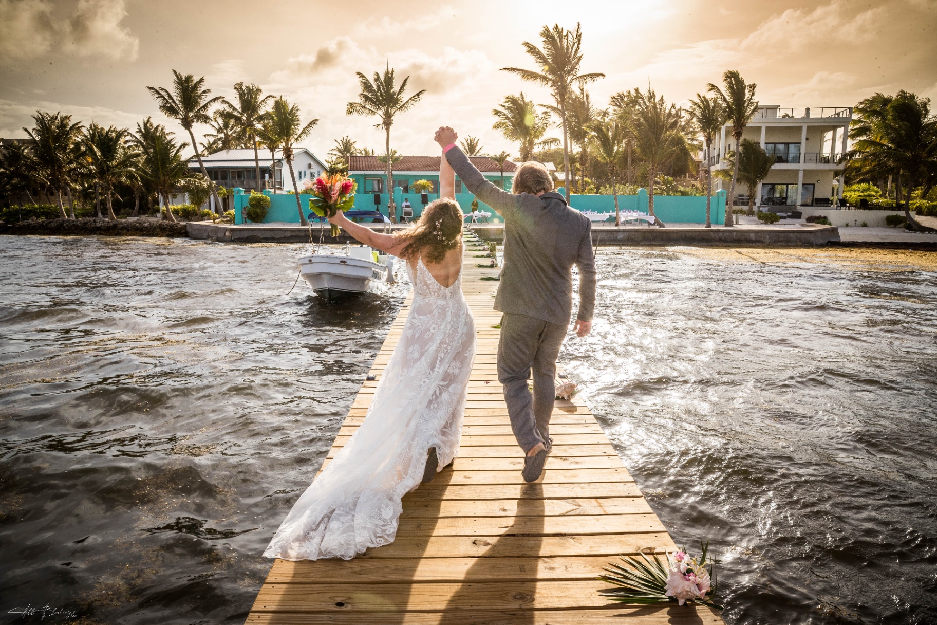 Newly married couple celebrating on the dock at Playa Blanca during golden hour