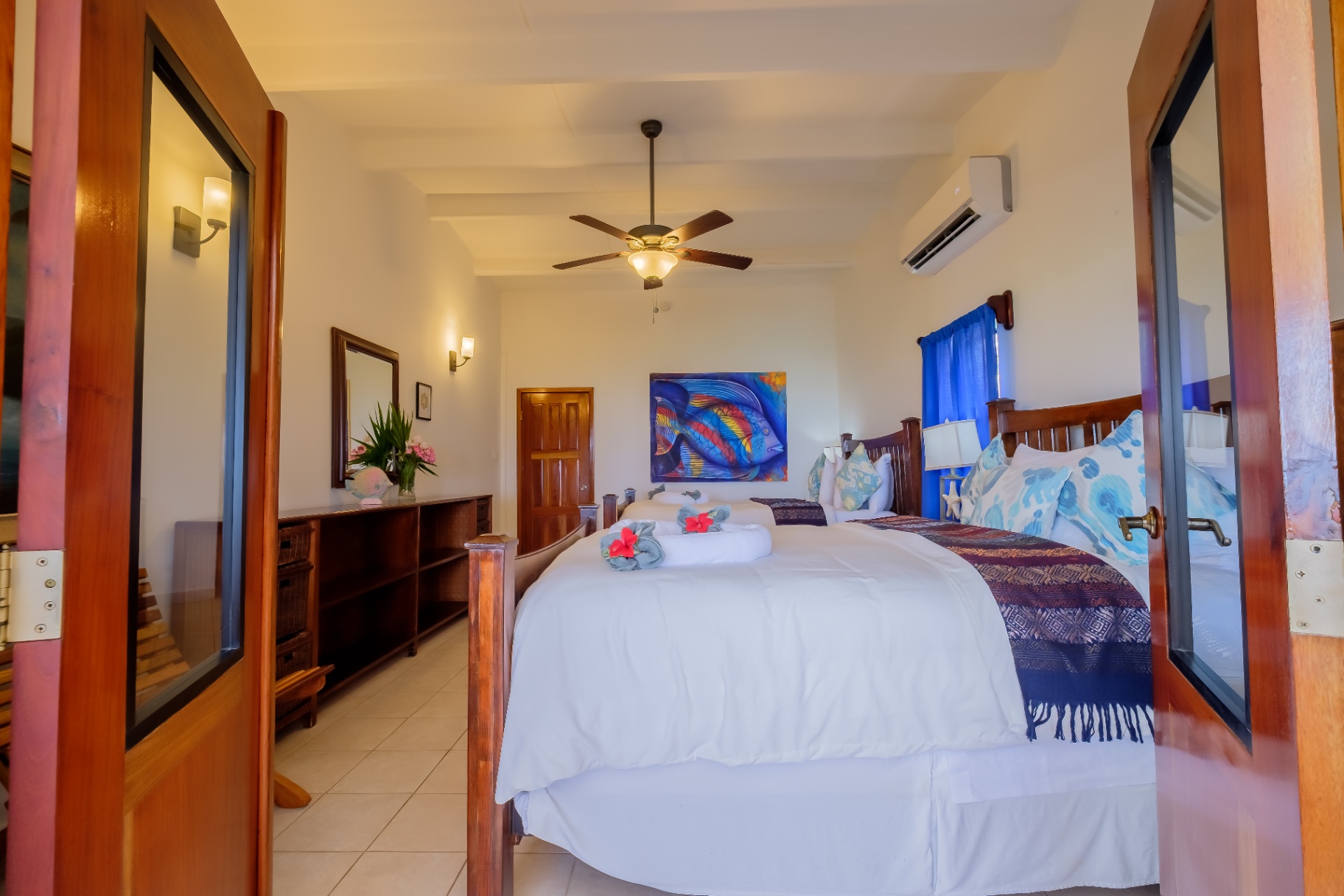 Double queen bedroom with colorful reef artwork