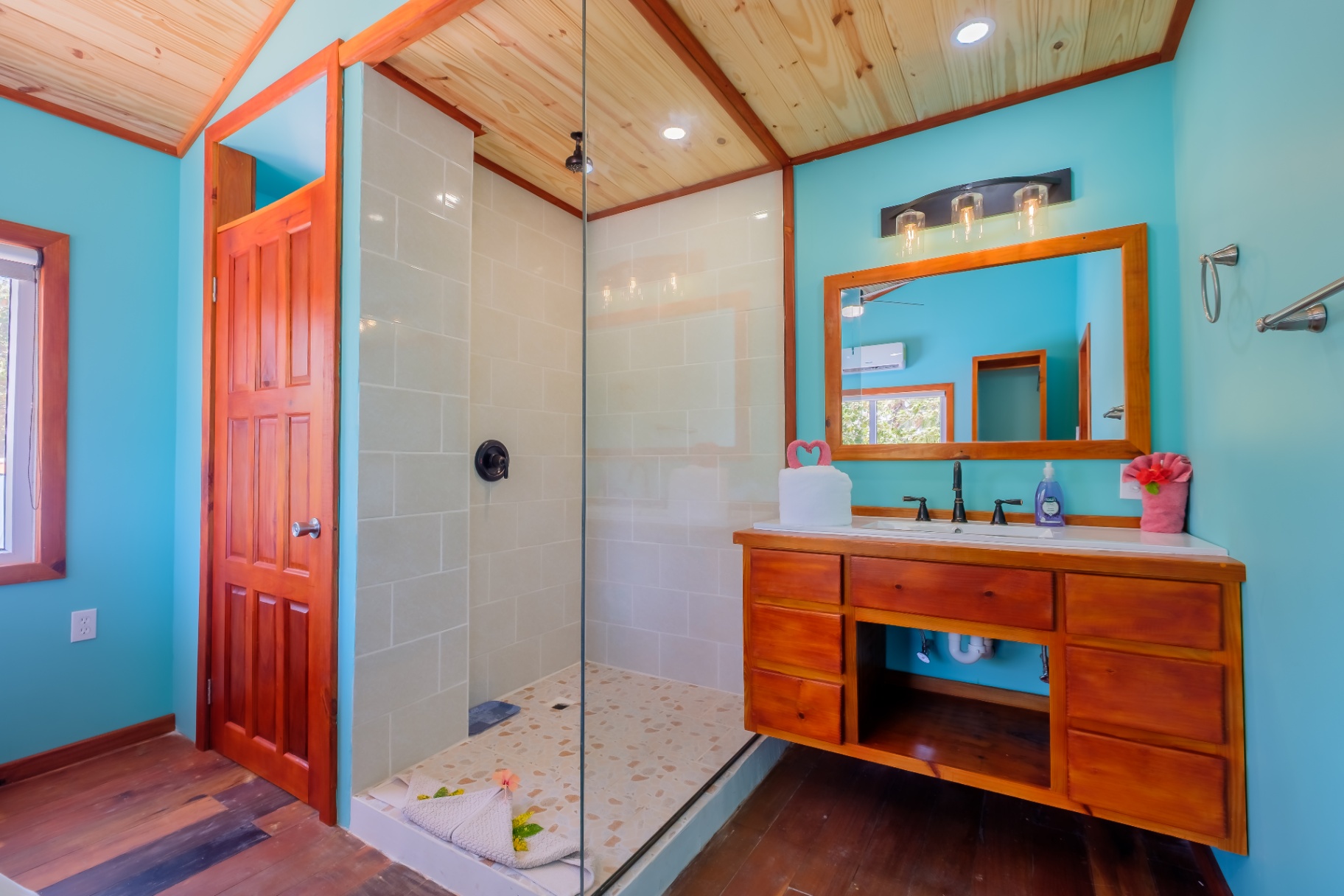 Studio bathroom with walk-in glass shower and hardwood vanity