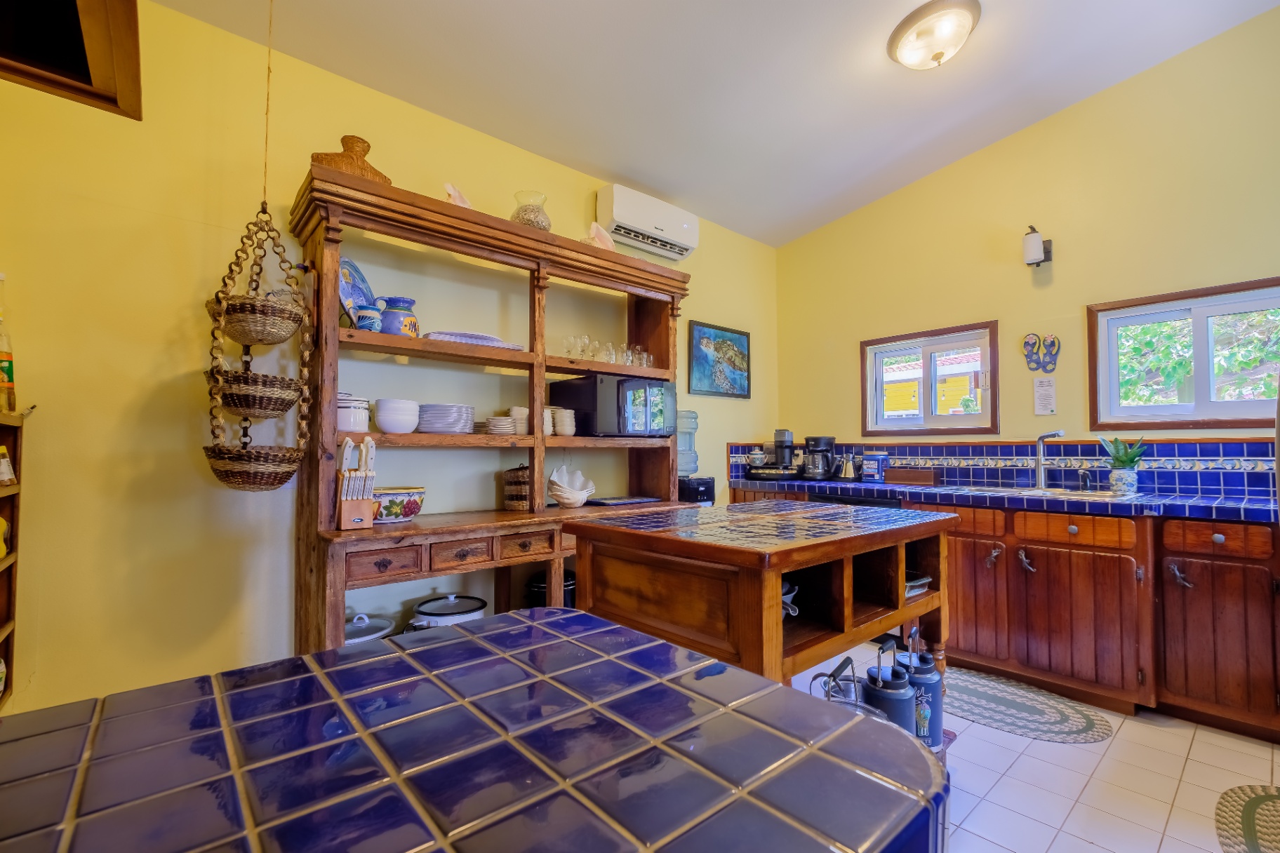 Wide view of the blue-tile kitchen and prep island