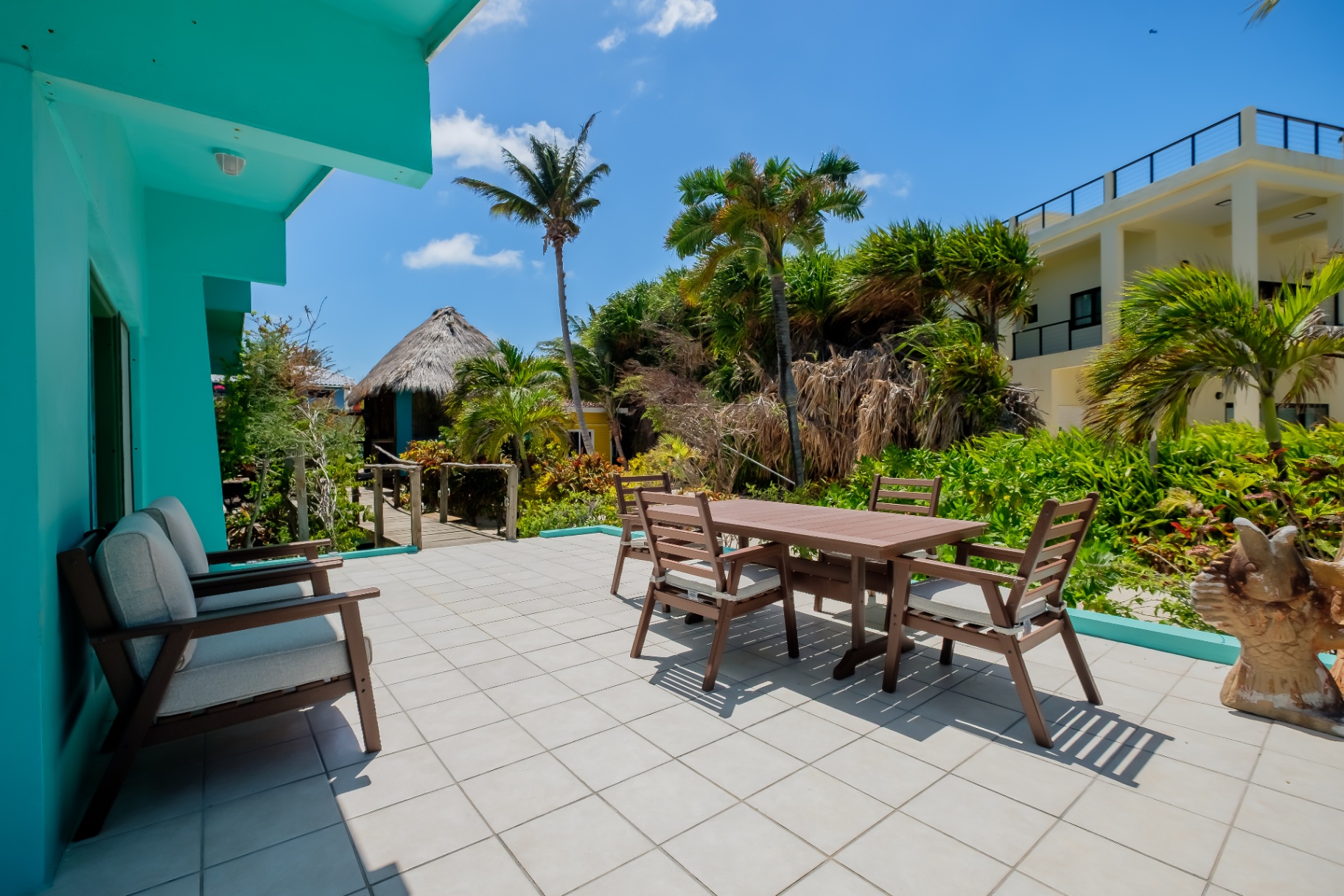 Turquoise patio with dining set and palapa beyond