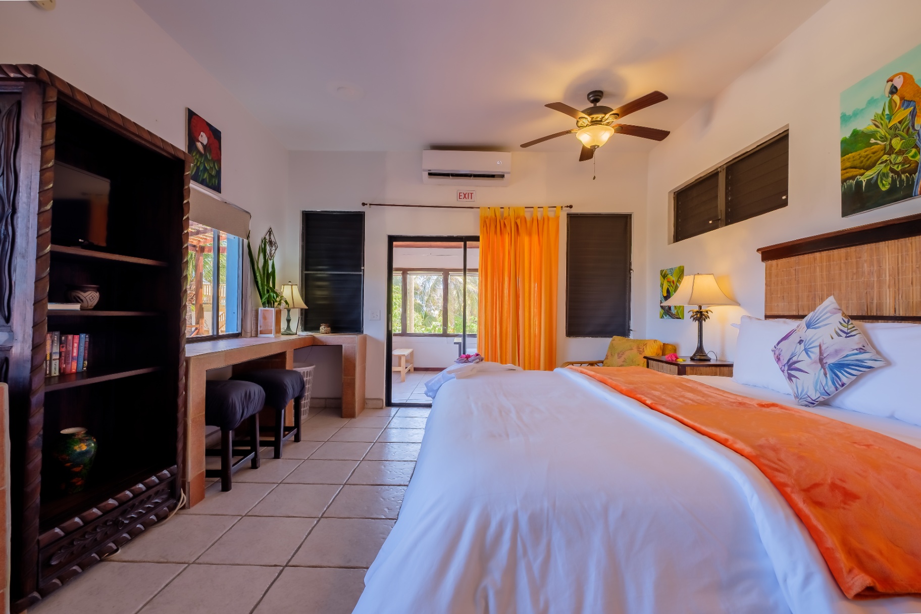 King bedroom with parrot artwork and balcony access