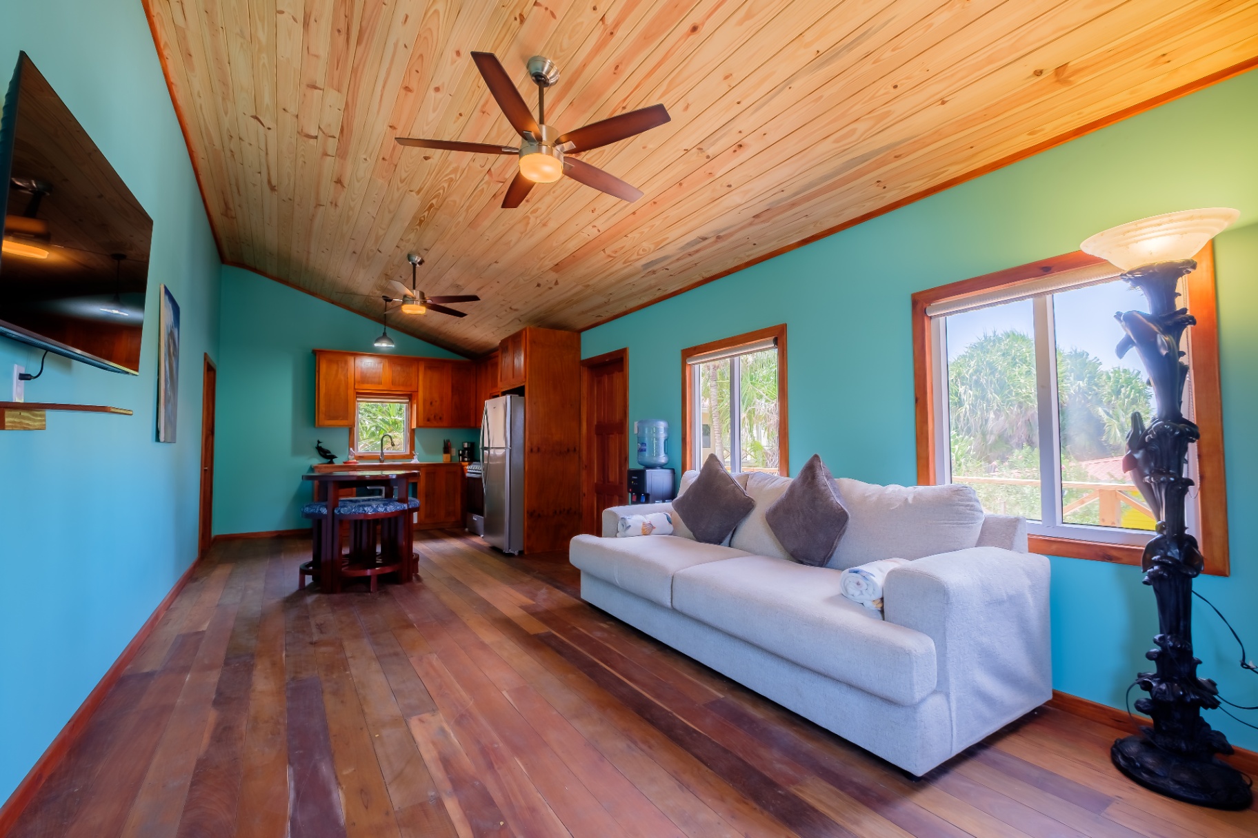 Living room with sofa, kitchen, and tropical views