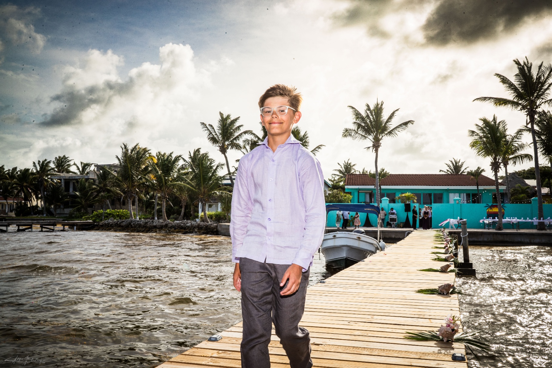 Young family member walking down the dock with Playa Blanca and the decorated reception space in the background