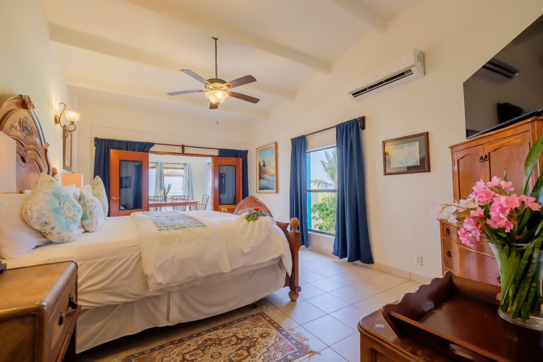 King bedroom with blue curtains and sea-view doorway