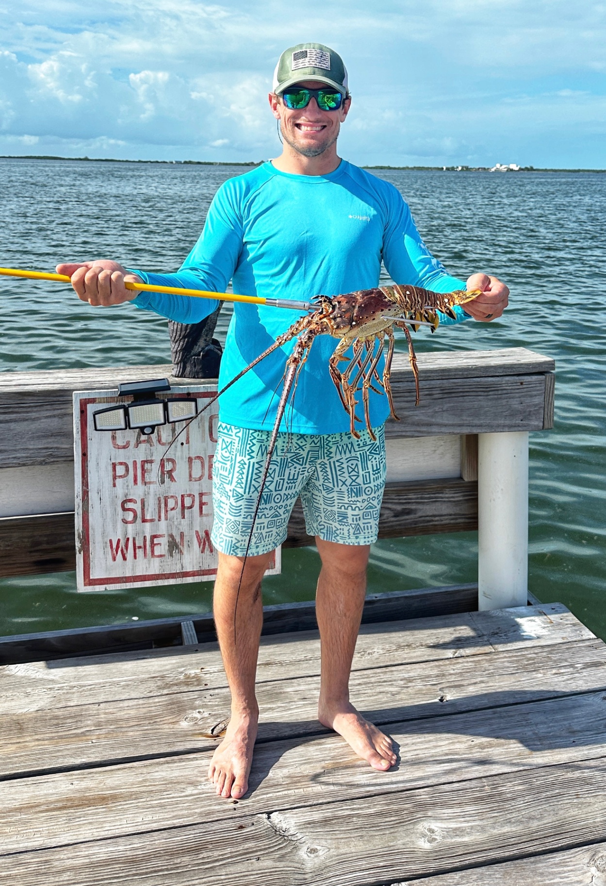 Playa Blanca guest holding fresh Belize spiny lobster on the dock
