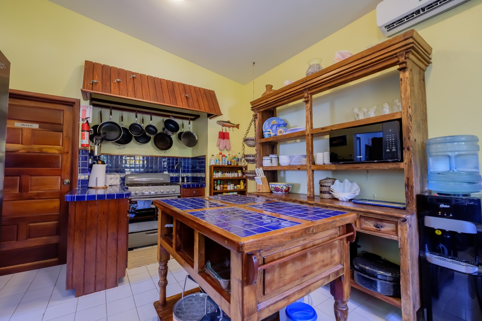 Kitchen with blue-tile island and hanging pots
