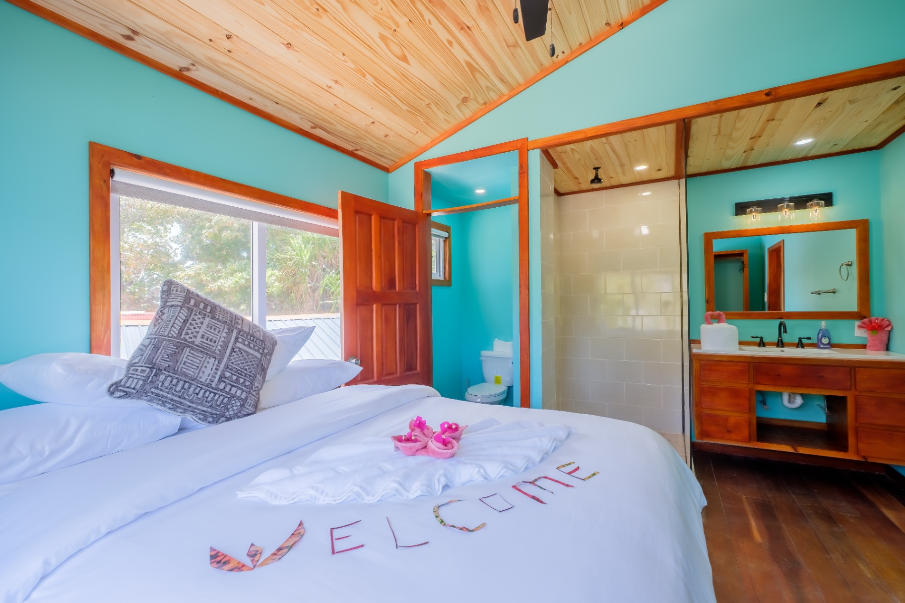 King bedroom with welcome towel art and ensuite shower