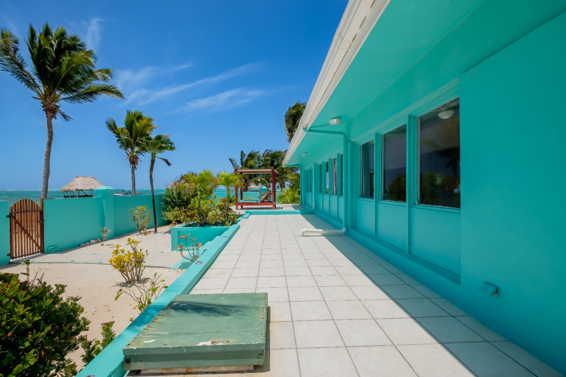 Side terrace with tiled walkway and palms to the reef