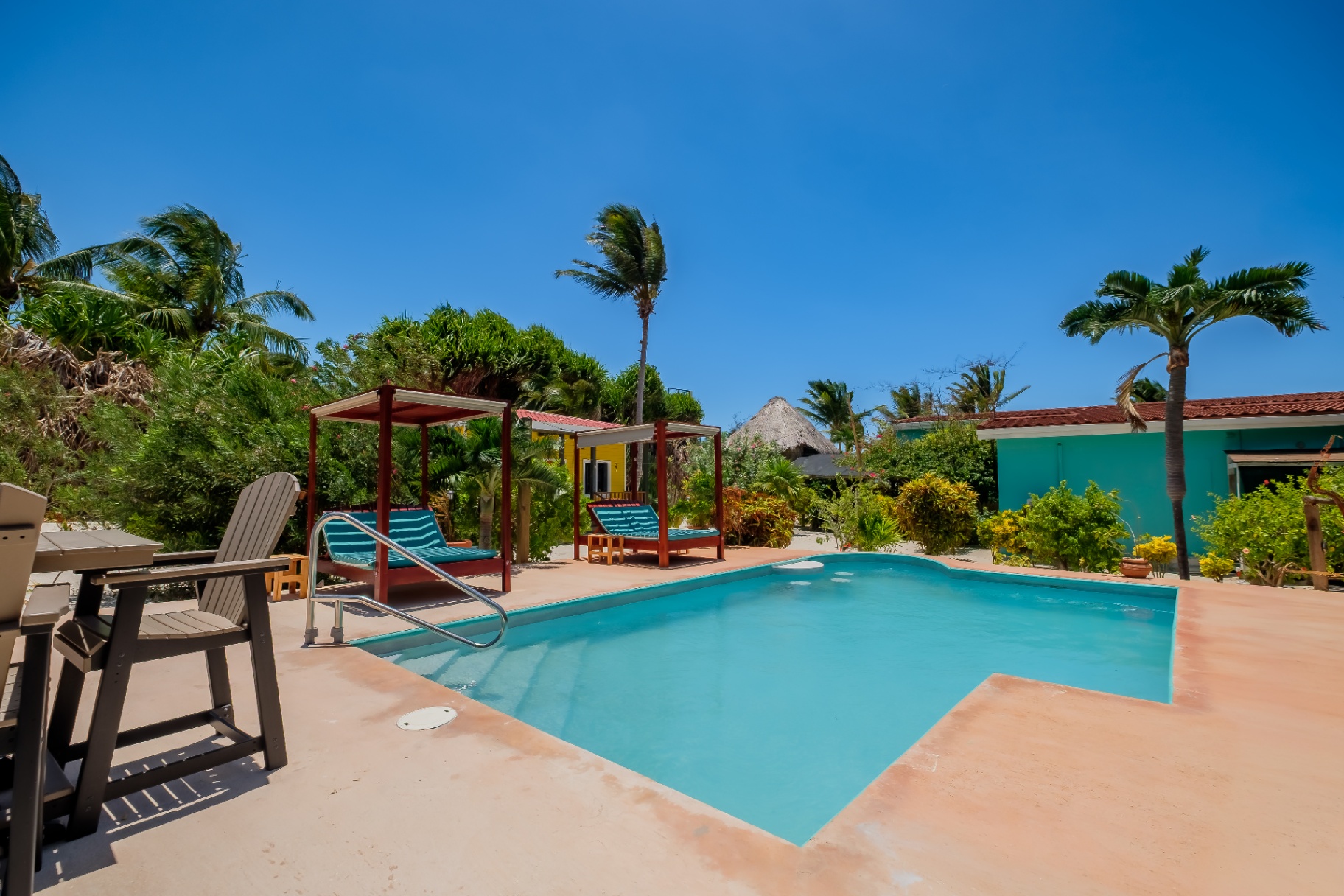 Pool with shaded daybeds and tropical garden