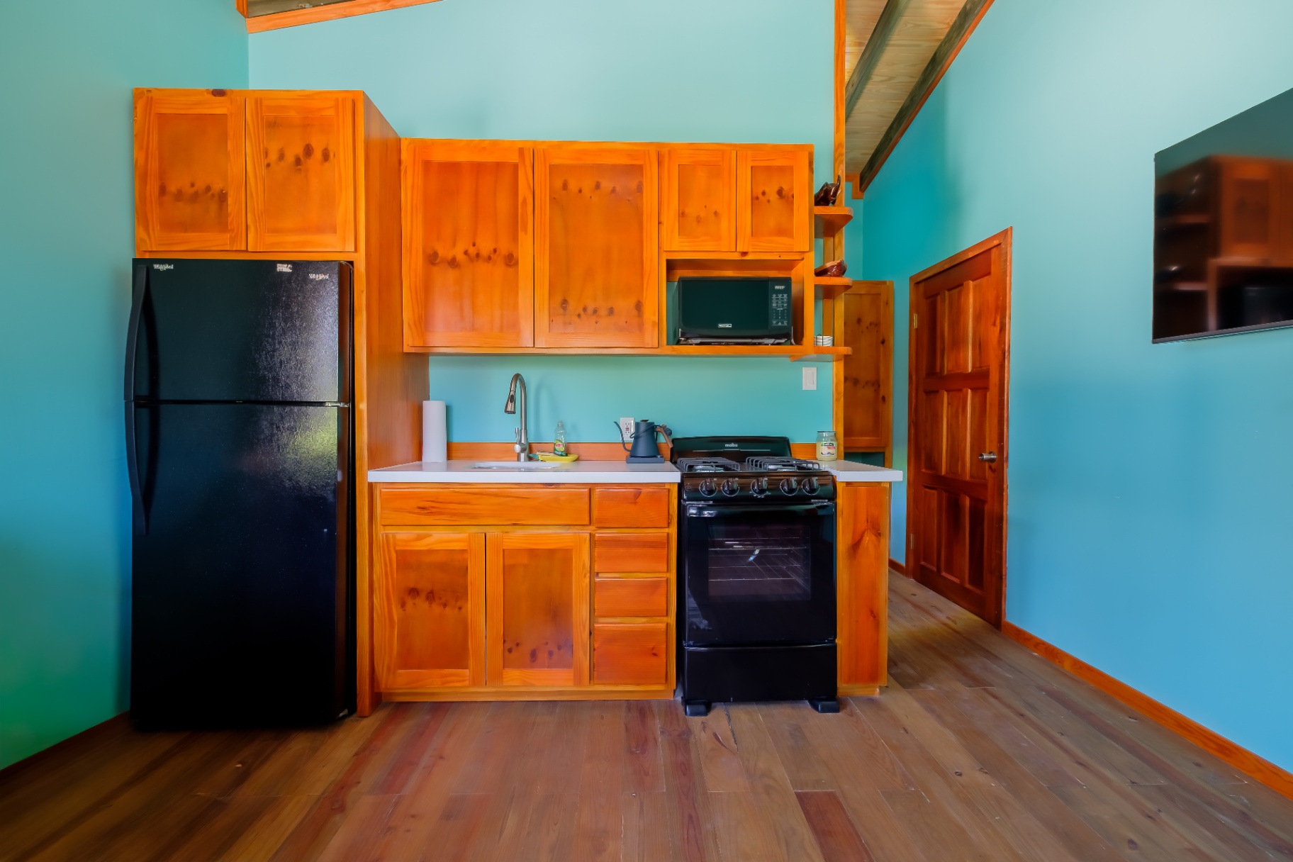 Full pine kitchen with gas range, fridge, and microwave