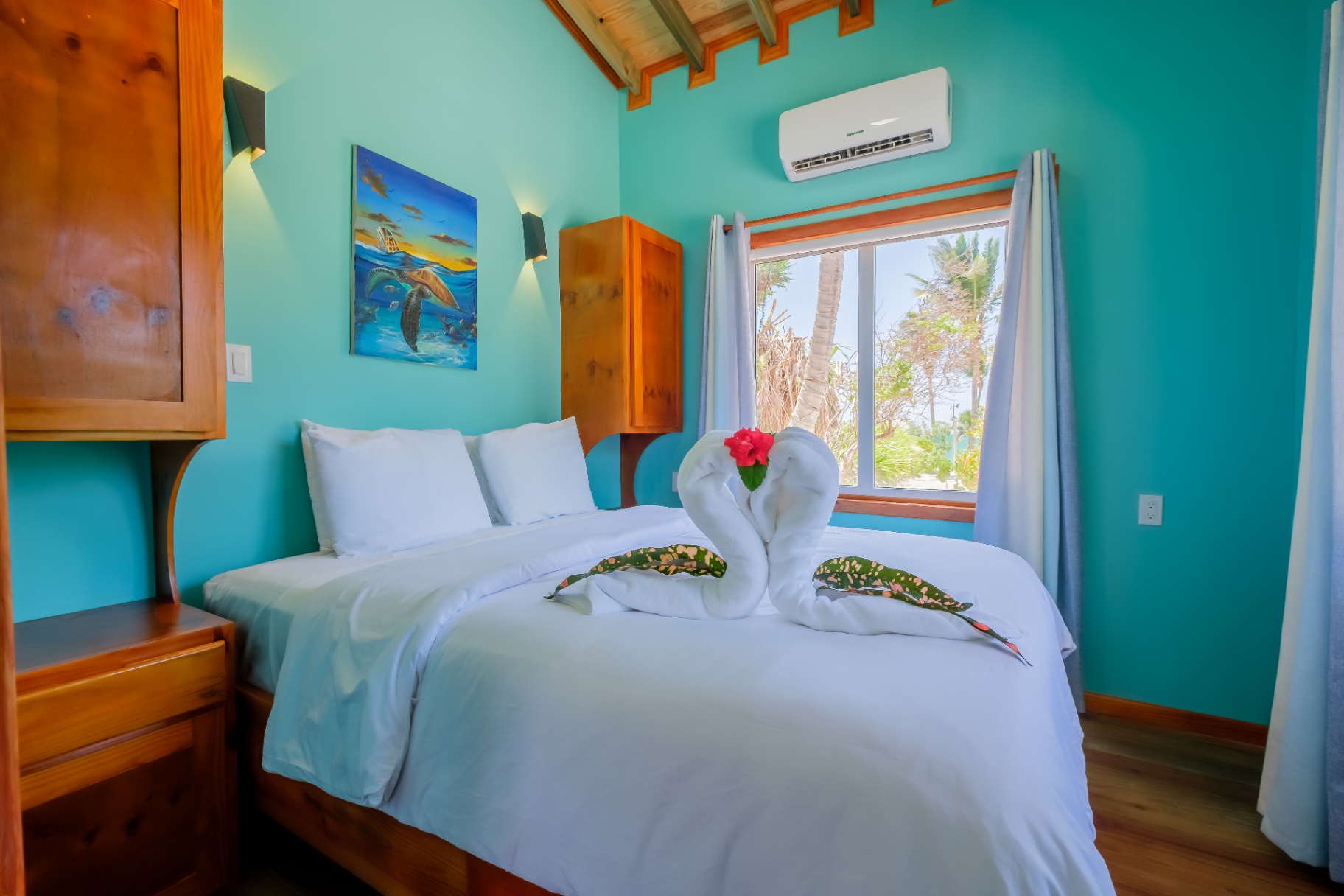 Queen bedroom with vaulted ceiling and palm-framed window
