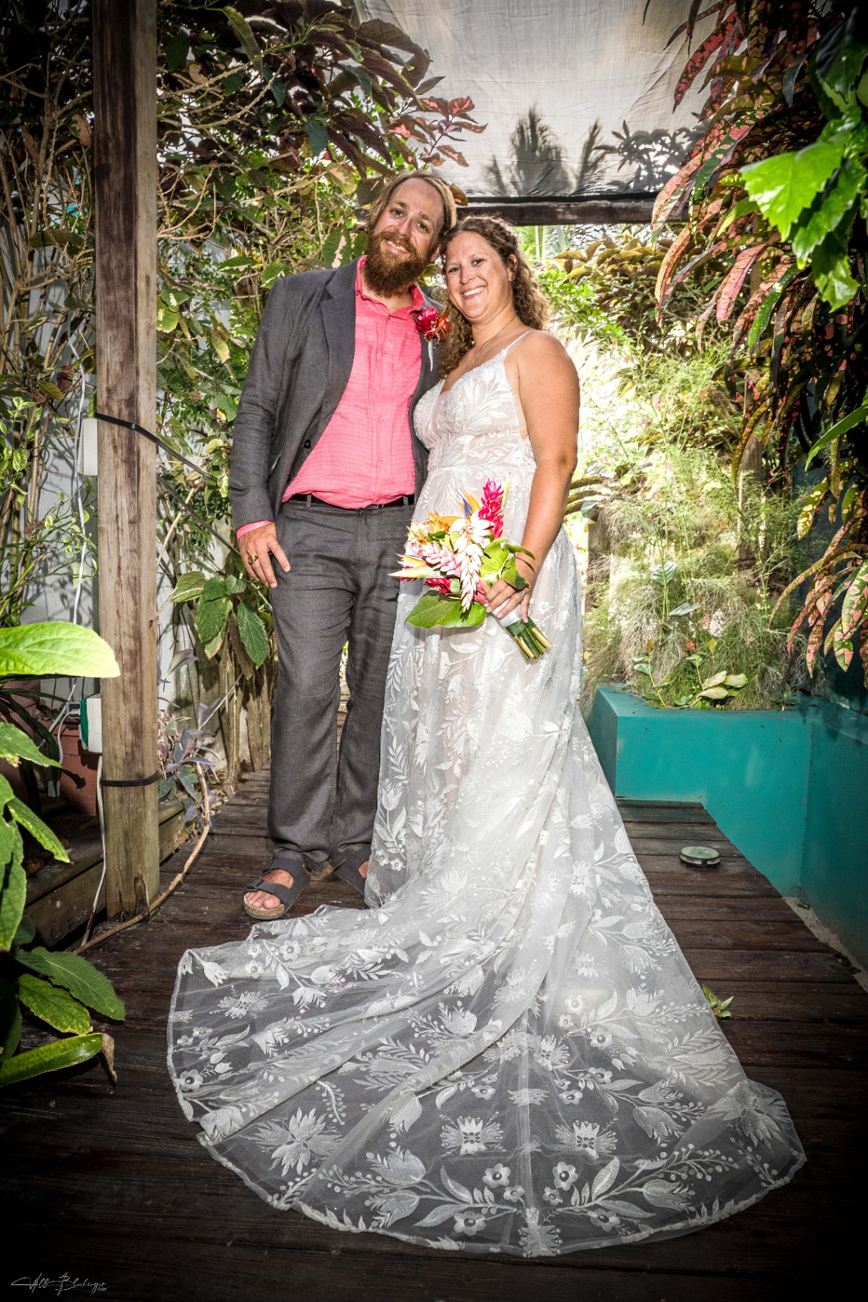 Bride and groom posing in a lush garden walkway on the Playa Blanca grounds