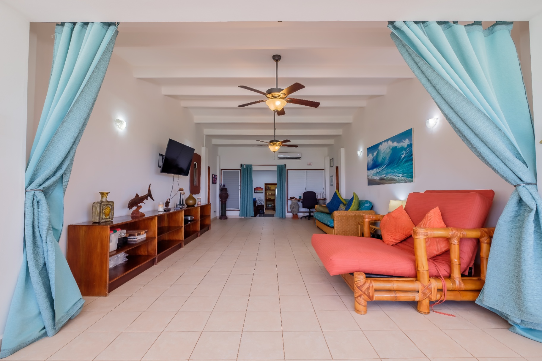 Living room framed by turquoise curtain archway