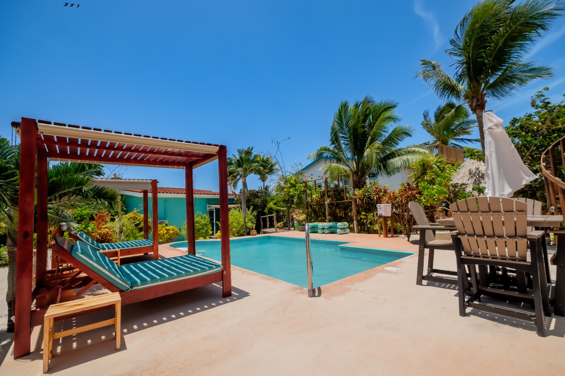 Pool cabana lounger with palms swaying overhead