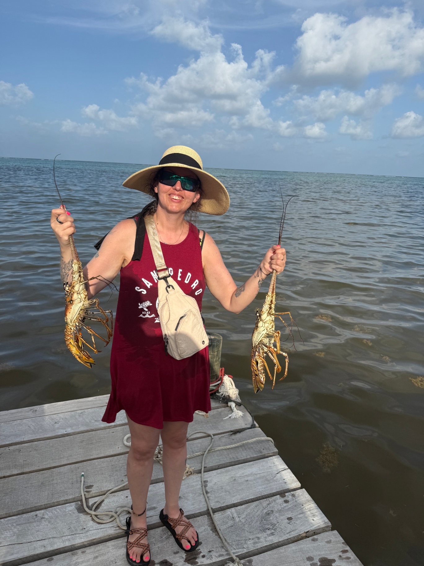 Playa Blanca guest holding fresh Belize spiny lobster on the dock
