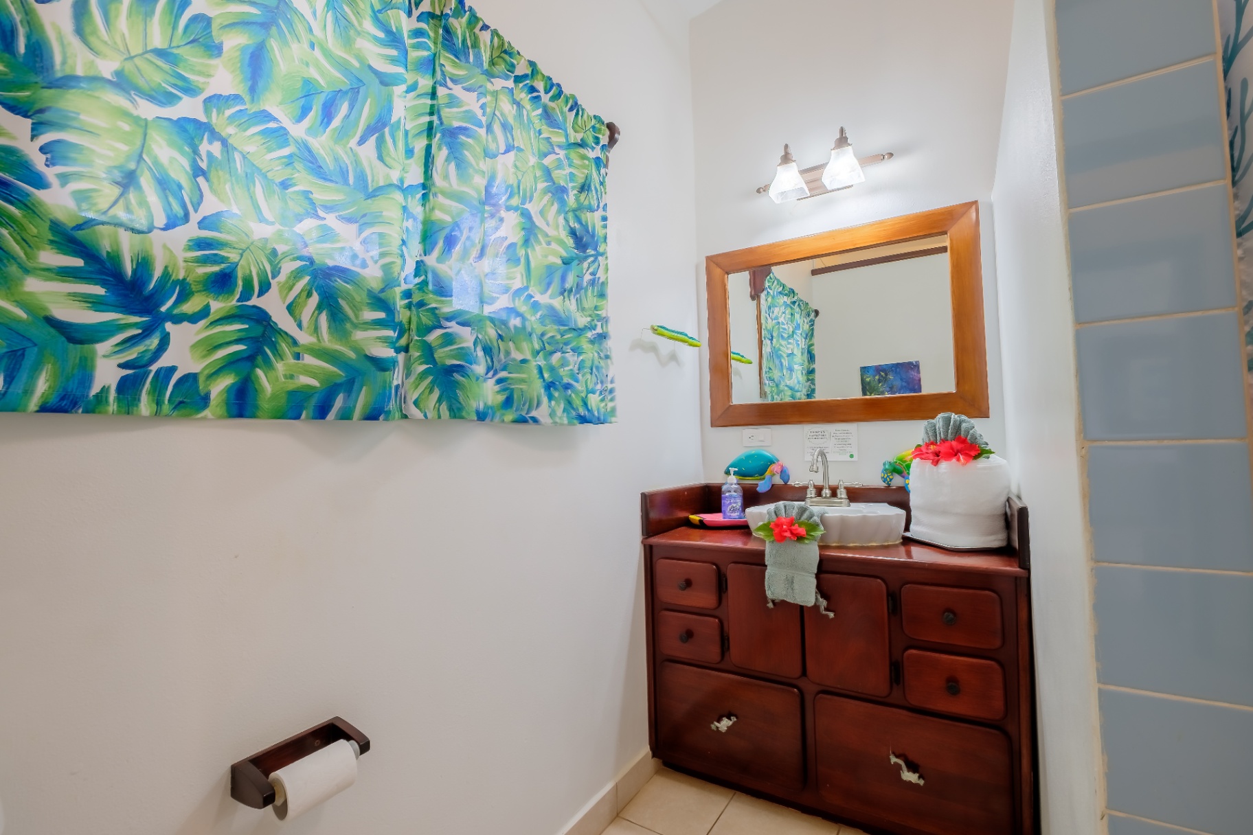 Powder room with tropical palm-print curtain