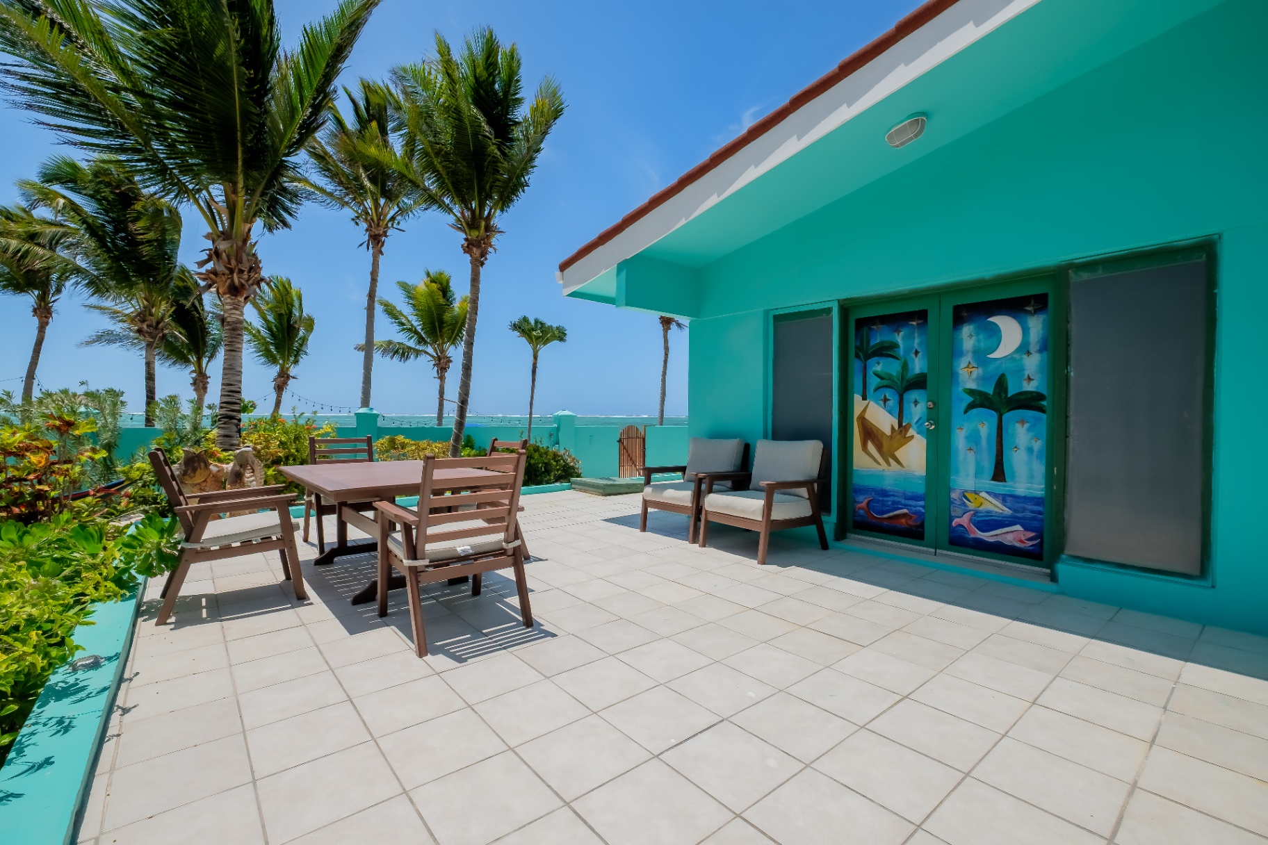Upper terrace with painted doors and palm-lined sea view