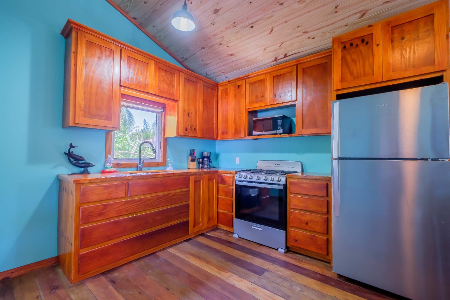 L-shaped kitchen with gas range and hardwood cabinetry