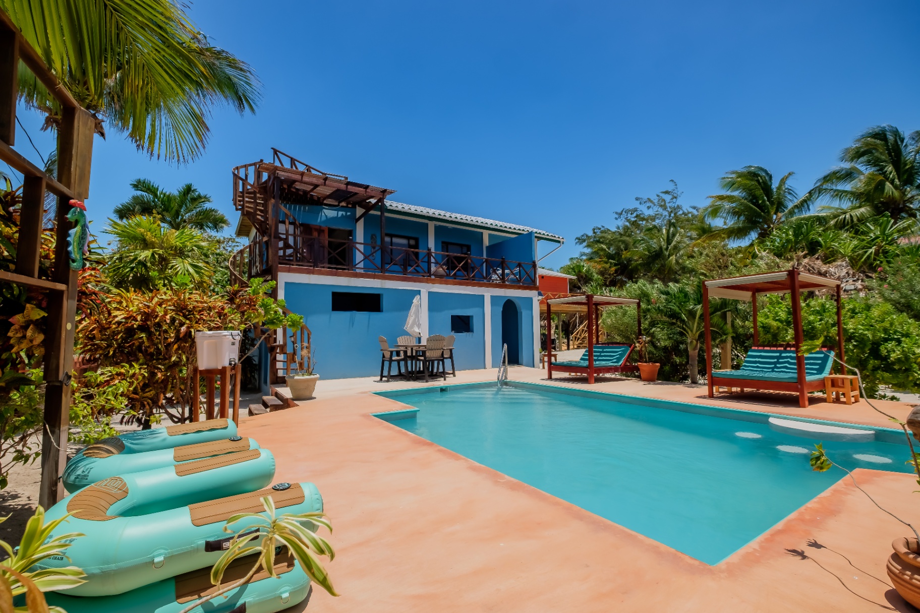 Blue House exterior with pool, daybeds, and rooftop deck