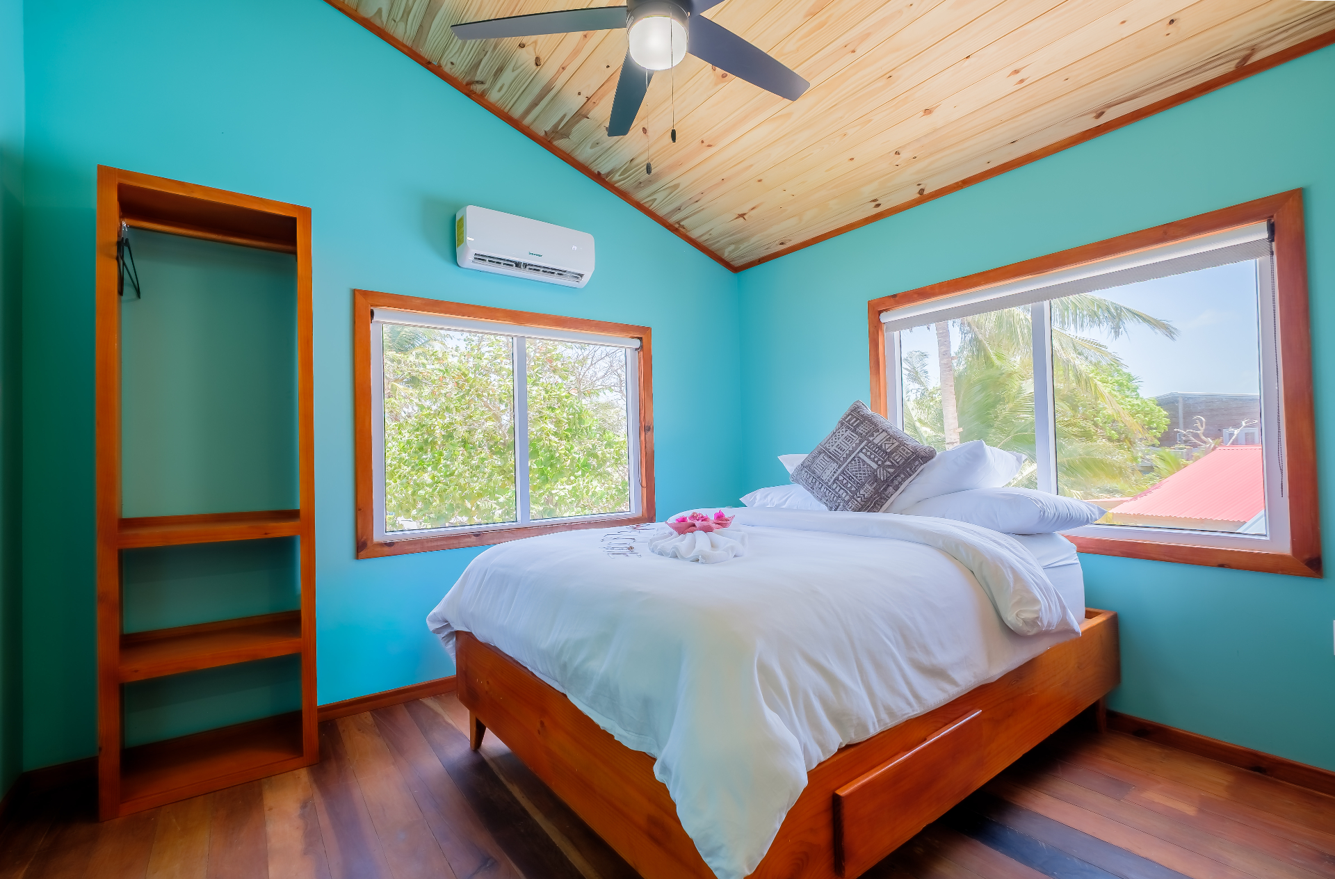 Queen bedroom with vaulted pine ceiling and tropical window views